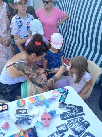 Audrey de Toutes Un Art pose un tatouage éphémère sur une enfant